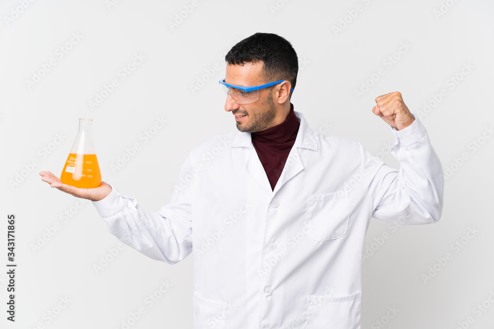 Young man over isolated white background with a scientific test tube and celebration Young man over isolated white background with a scientific test tube and celebration