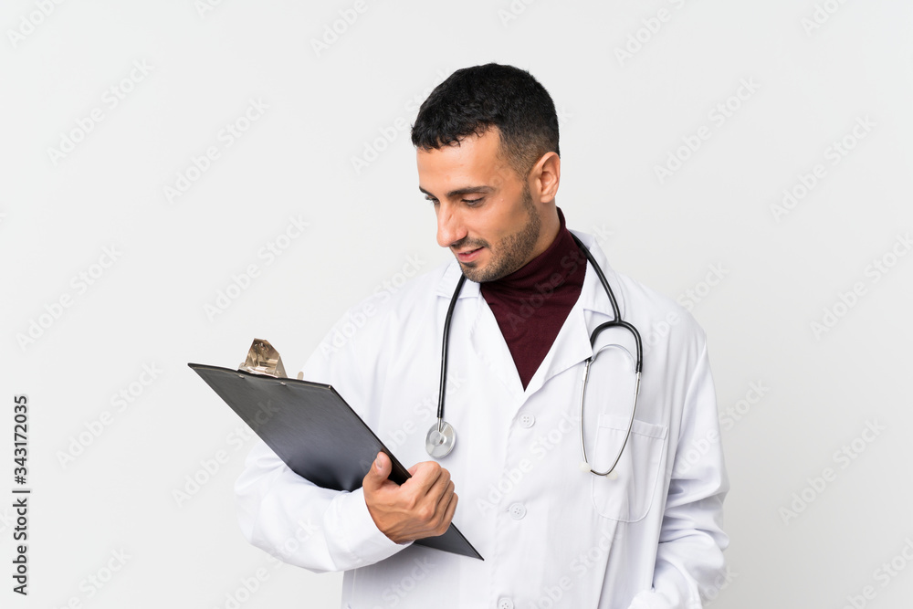 Young man over isolated white background with doctor gown and holding a folder Young man over isolated white background with doctor gown and holding a folder