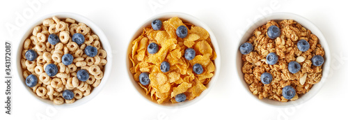 Three bowls of cereals with blueberries isolated on white, from above