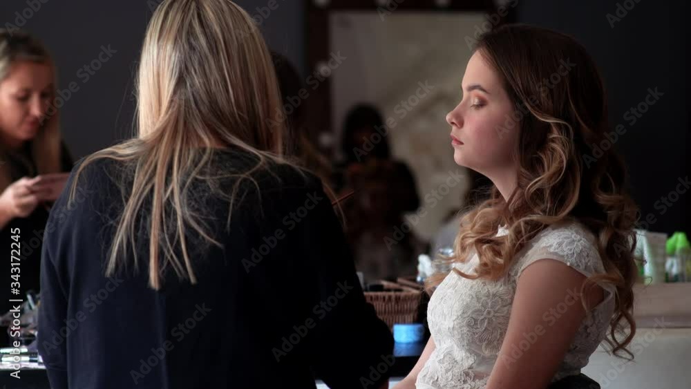 Makeup artist paints the eyes of a girl model Makeup artist paints the eyes of a girl model