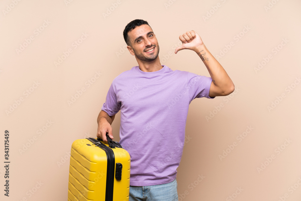 Man holding a suitcase over isolated background proud and self-satisfied Man holding a suitcase over isolated background proud and self-satisfied