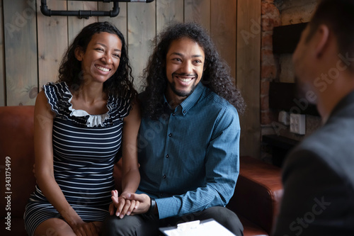 Photos Happy biracial young couple hug after successful relationships therapy with male