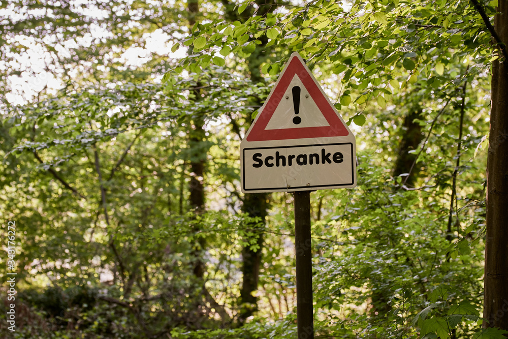 A red and white warning sign for a barrier in the forest 