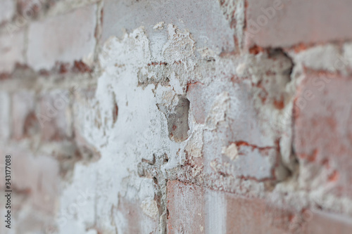 Old brick wall with white paint background texture close up. Side view, low depth of field.