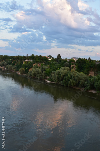 The green bank of the Danube River with several houses above the river