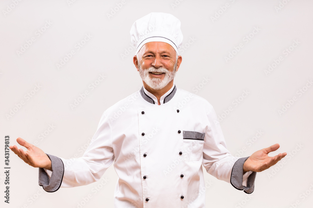 Portrait of senior chef gesturing on gray background. Portrait of senior chef gesturing on gray background.