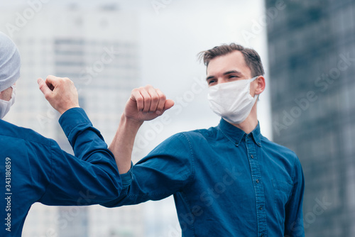 close up. friends in protective masks greeting each other