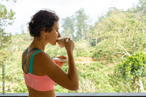 Girl drinks tea with a view of the jungle in Sri Lanka