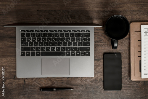 workplace composition with laptop, smartphone, notepad, coffee and pen