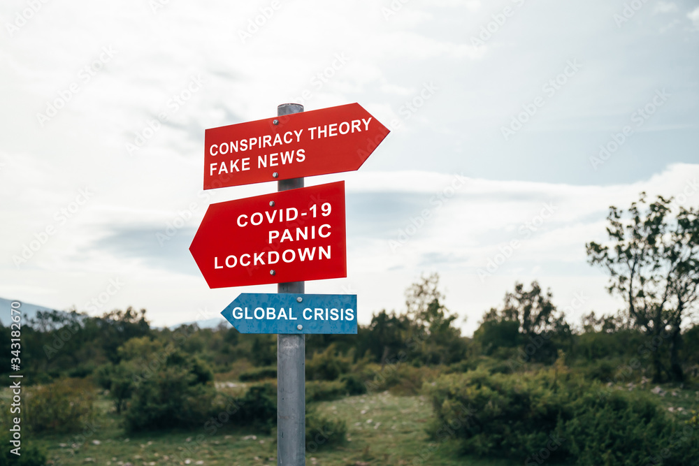 Conspiracy theory, fake news, Covid-19, panic, lockdown, global crisis road warning signs. Social media campaign for coronavirus plus total disorientation an fear in society