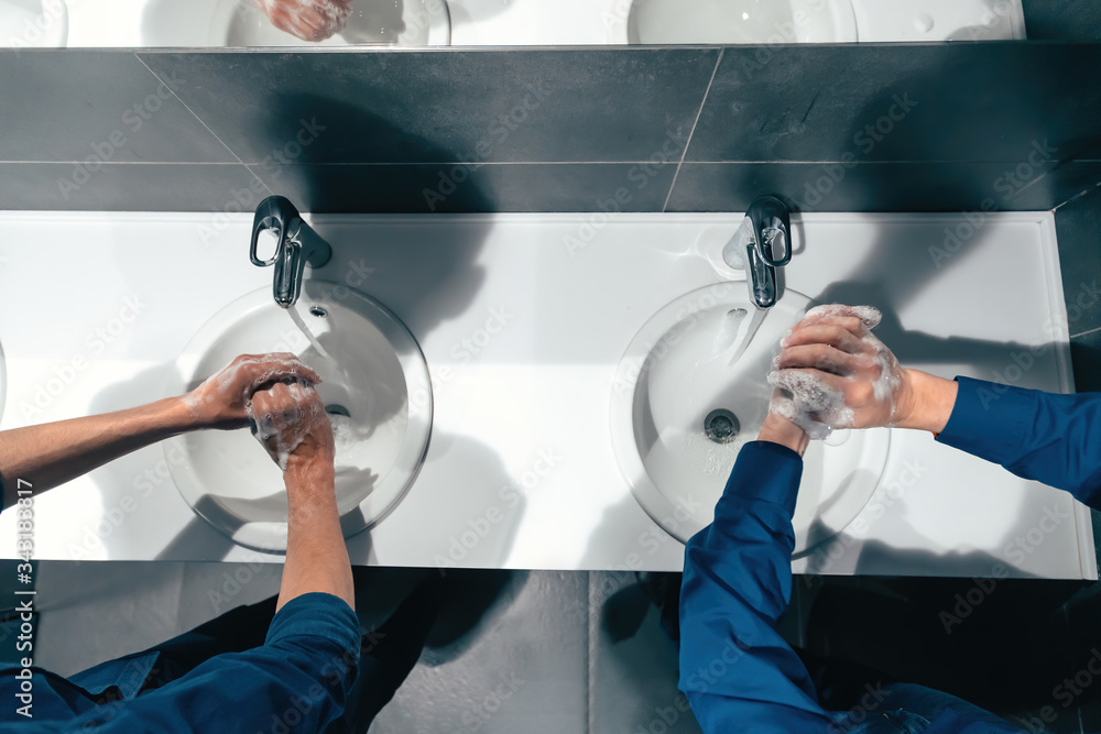 top view . colleagues wash their hands in the office restroom