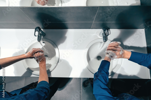 Obraz na płótnie top view . colleagues wash their hands in the office restroom w salonie