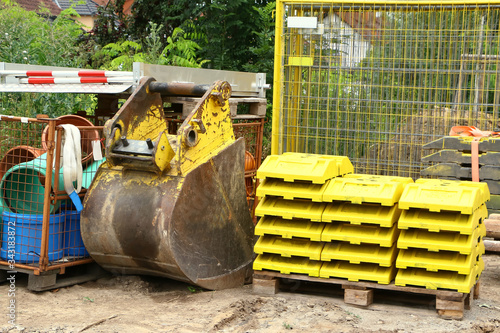 Gelbe Fußplatten auf einer Baustelle und Baggerschaufel photo