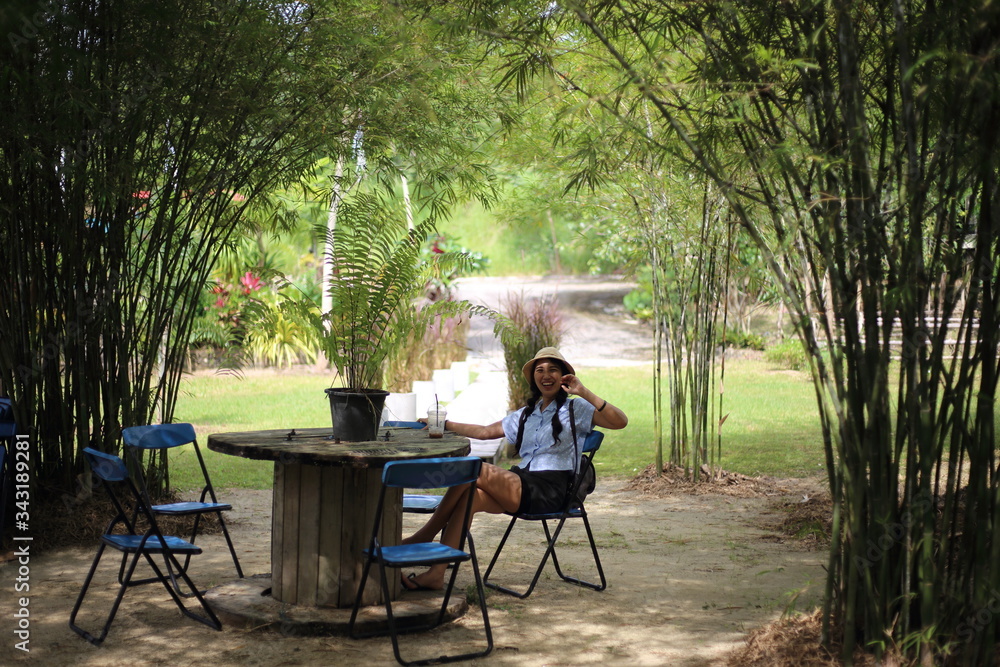 Woman sitting in a bamboo garden in Rayong, Thailand Woman sitting in a bamboo garden in Rayong, Thailand