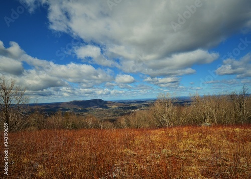 Blue Sky with Puffy White Clouds - Harmon Hill Mountain Top Lookout. Dry earth foreground, early spring 2020