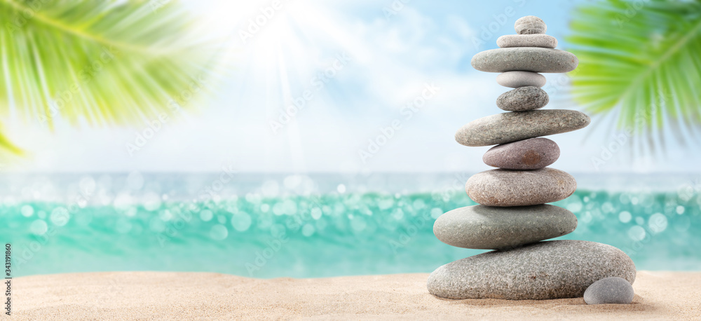 Pyramid of sea pebbles on a sunny sand beach Pyramid of sea pebbles on a sunny sand beach