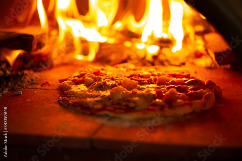 Pizza in charcoal grill, puffed dough cooked,soft focus