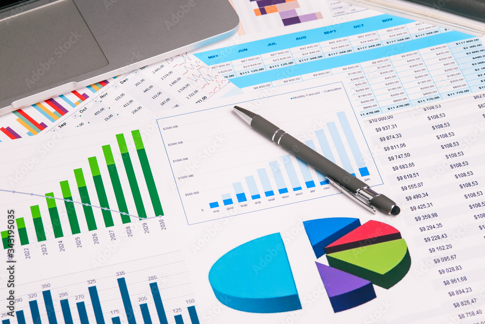 Computer, graphics and pen on the desktop. Research and Analytics in business. The development of enterprise and accounting. Computer, graphics and pen on the desktop. Research and Analytics in business. The development of enterprise and accounting.