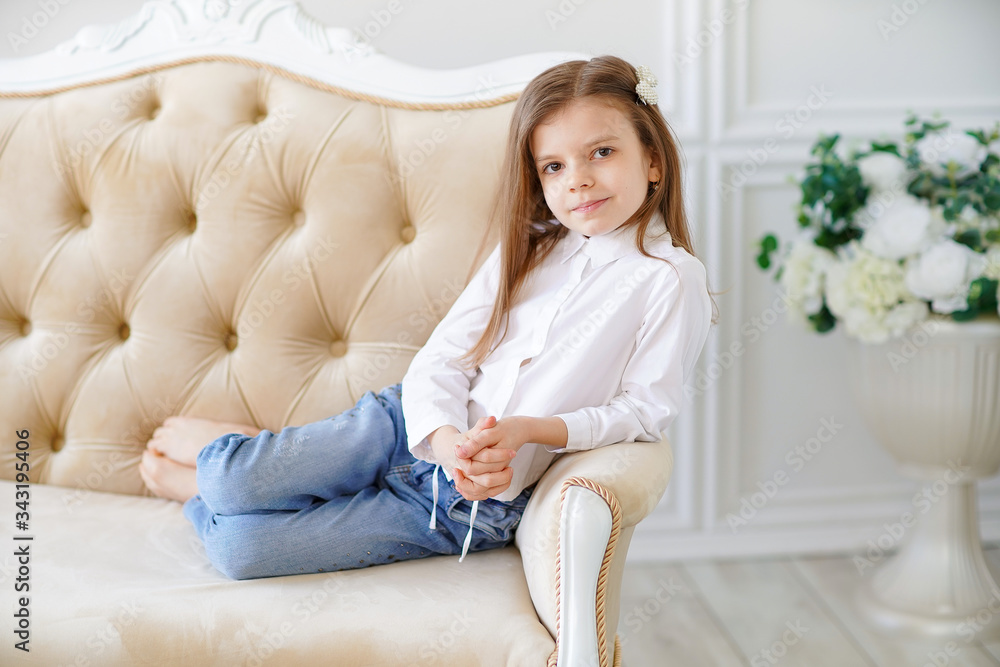Little cute girl lies on the sofa in the room. Little cute girl lies on the sofa in the room.