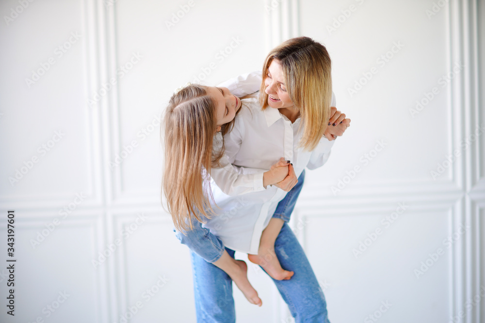Fototapeta premium Portrait of little girl loving mother and holding her.