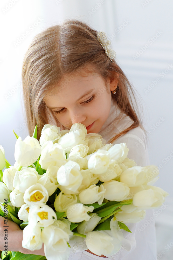 Portrait of beautiful pretty girl with white flowers tulips. Indoor photo. Portrait of beautiful pretty girl with white flowers tulips. Indoor photo.