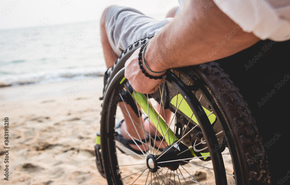 Fototapeta premium Disabled man in a wheelchair on the beach.
