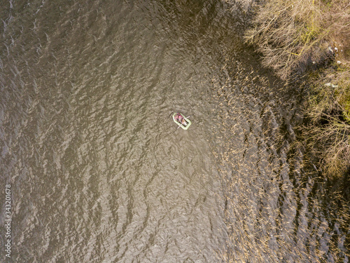 Fishing inflatable boat on a forest lake. Aerial drone view.