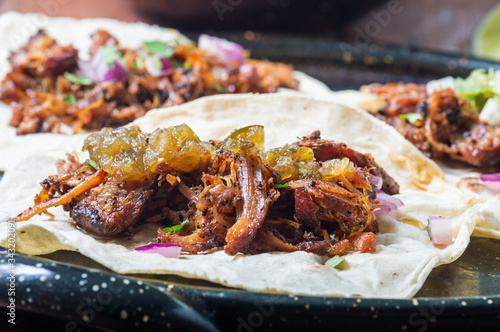 Carnitas tacos with red onion and raw green salsa