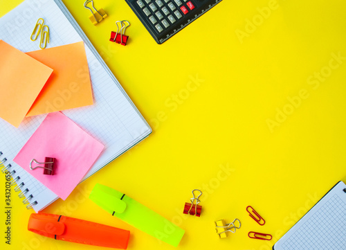 open notebook in a ruler on a yellow background. next to office supplies. business concept for a girl or back to school