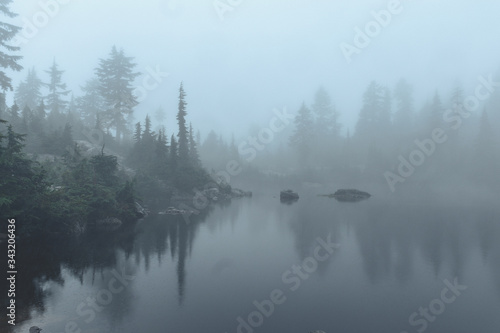 mountain lake surrounded by forest in the fog © BennyTakesSomePics