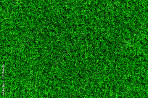 Green artificial grass background. Golf, football or soccer field. Сan be used for seamless texture of grass. Top view. Soft green environmental backdrop.