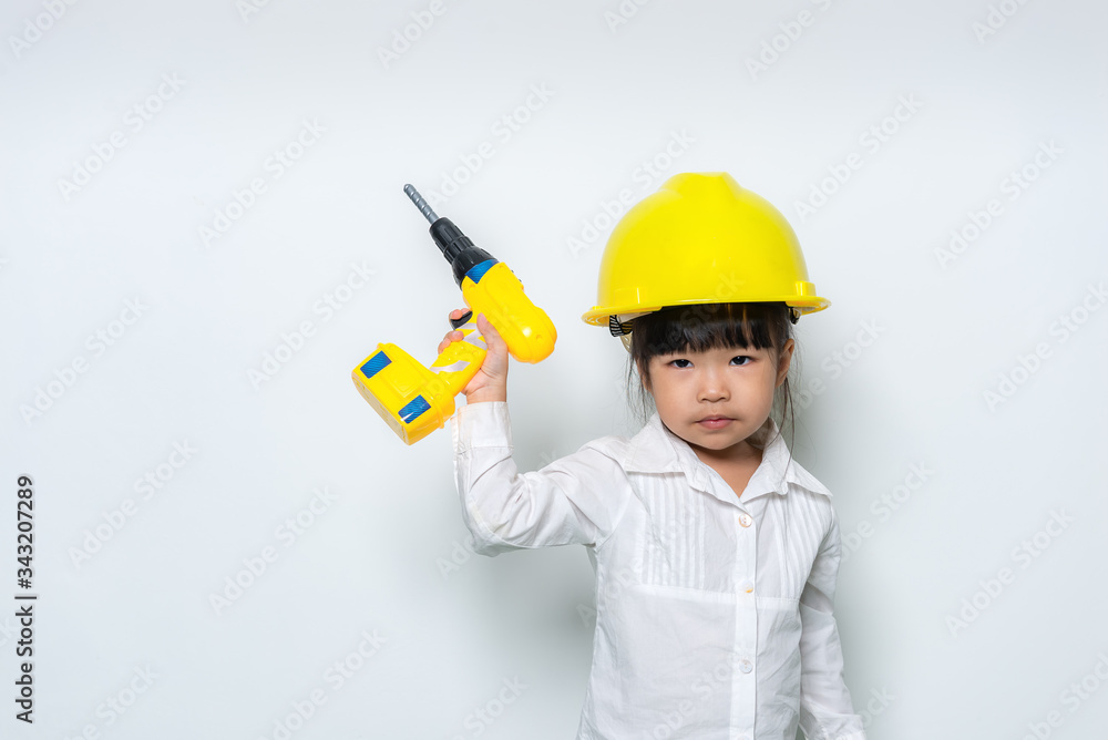 Portrait of cute asian little girl in engineer uniform and helmet on white background
