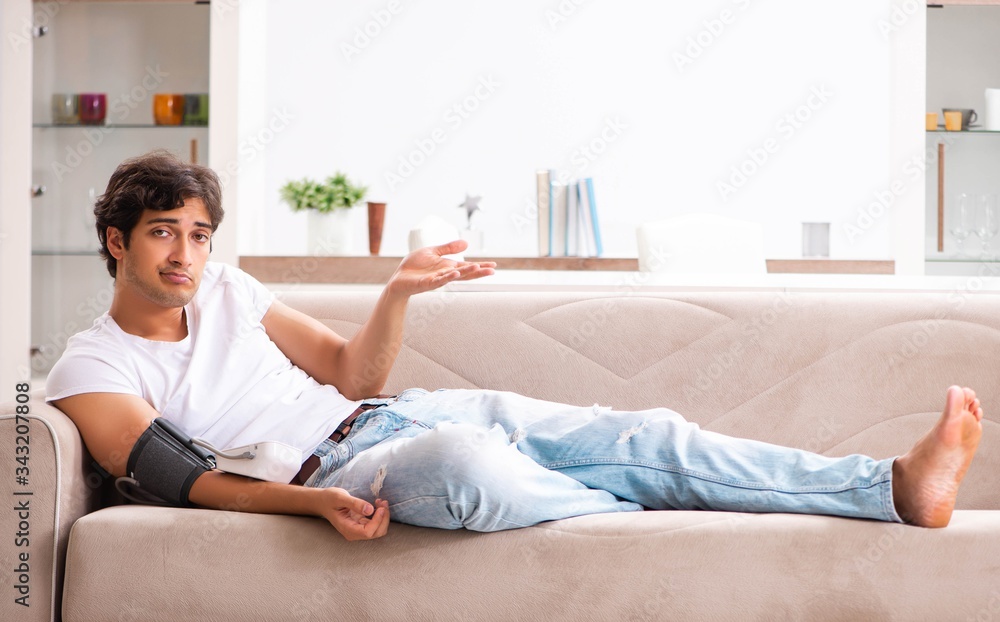 Young man measuring blood pressure at home Young man measuring blood pressure at home