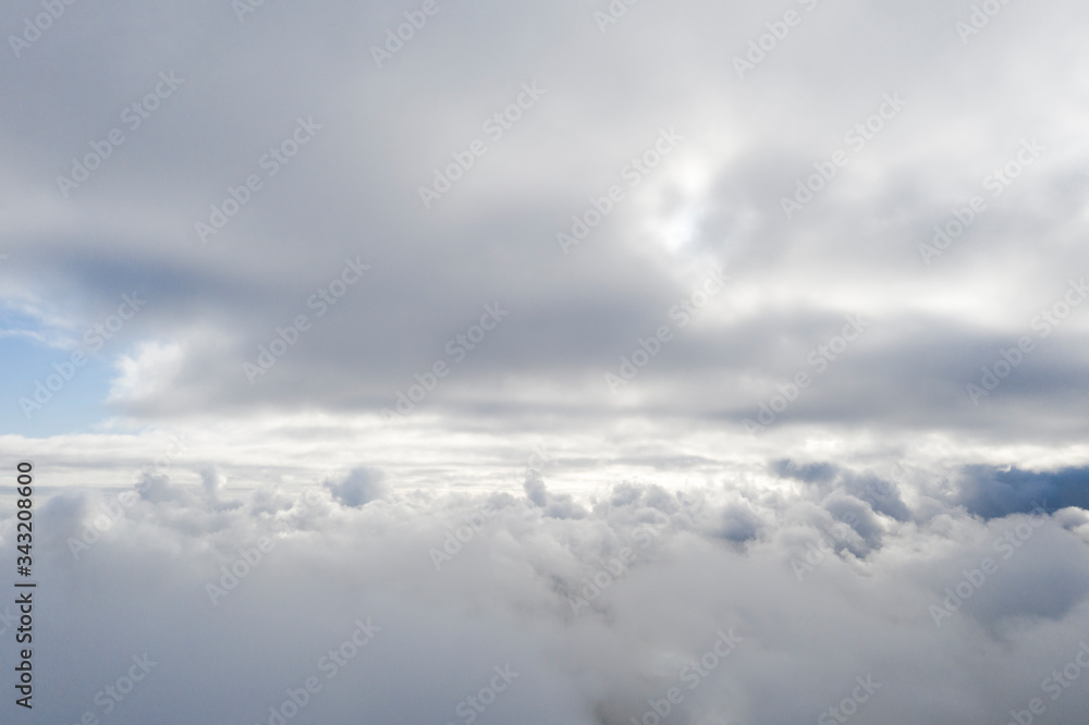 Obraz premium Aerial view white clouds in blue sky. View from drone. Aerial top view cloudscape. Texture of clouds. View from above. Sunrise or sunset over clouds. Panorama clouds
