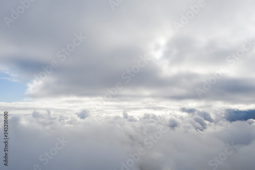 Aerial view white clouds in blue sky. View from drone. Aerial top view cloudscape. Texture of clouds. View from above. Sunrise or sunset over clouds. Panorama clouds © Aleksei