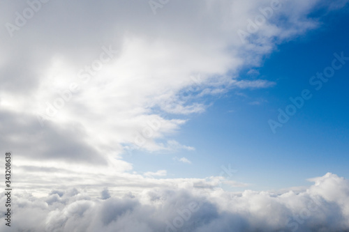 Aerial view white clouds in blue sky. View from drone. Aerial top view cloudscape. Texture of clouds. View from above. Sunrise or sunset over clouds. Panorama clouds