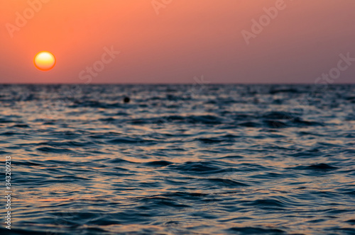 Fototapeta Naklejka Na Ścianę i Meble -  Amazing sea sunset on the pebble beach, the sun, waves, clouds