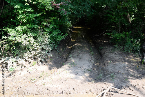 Dirty blurred forest road with deep rut. photo