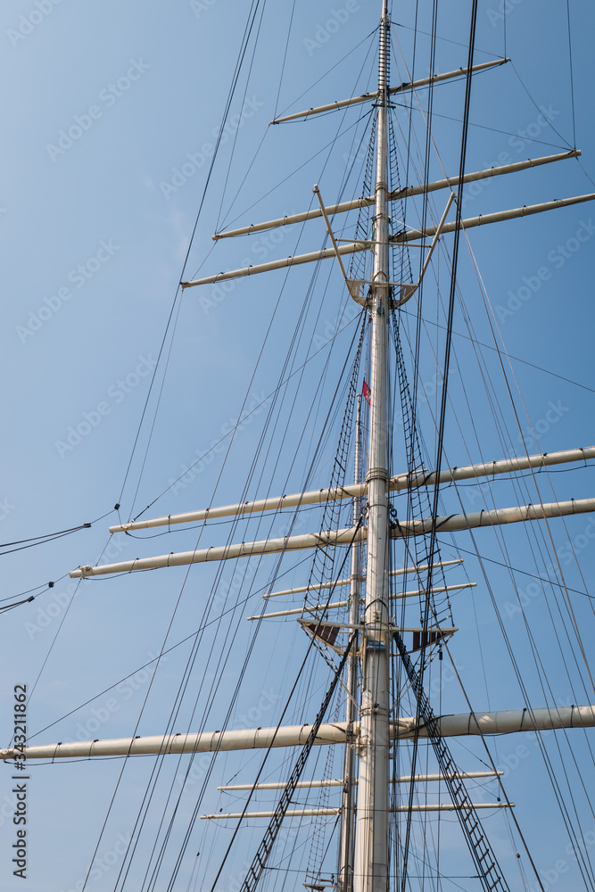 The empty masts of a three-masted sailing boat