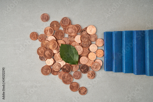 pile of coins with a green leaf and blue stairs