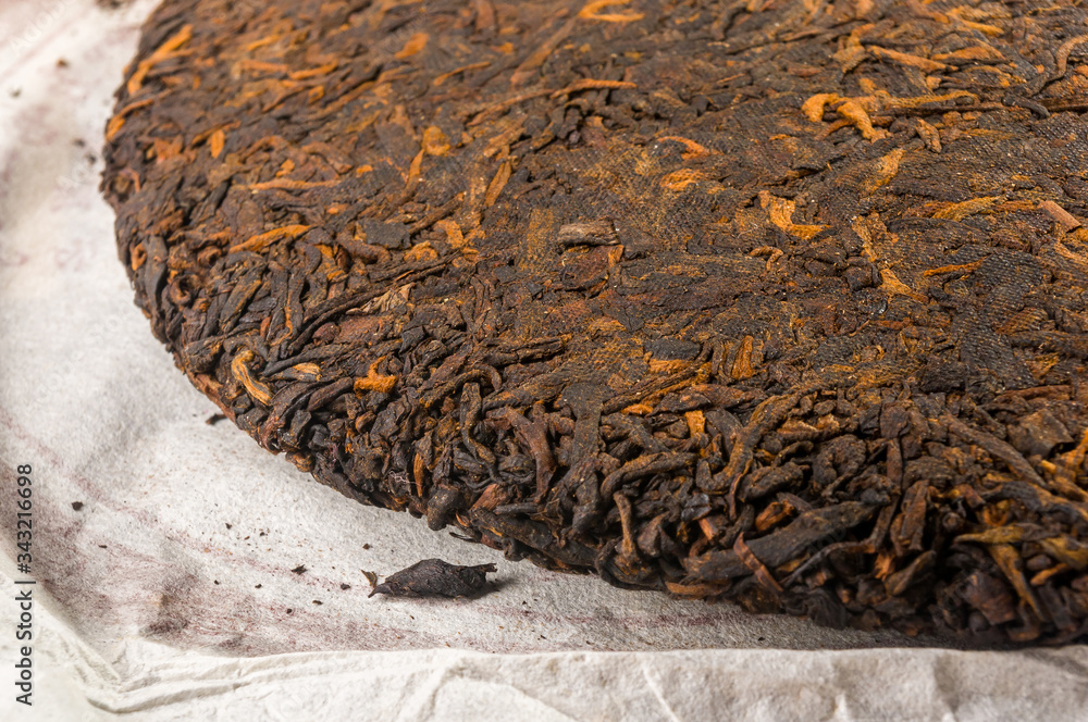 Naklejka premium Chinese pressed PU-erh tea on wrapping paper, close-up, macro