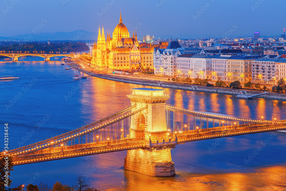 Budapest, Hungary. Night view on Parliament building and Chain Bridge over delta of Danube river. Picturesque view of illuminated night European capital city.