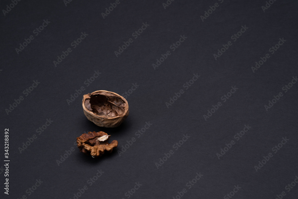 Walnut shell on a matte black background. Copy space. Dark mode Walnut shell on a matte black background. Copy space. Dark mode