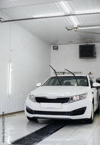 Modern washing with foam and high-pressure water of a white car. Car wash © Andrii