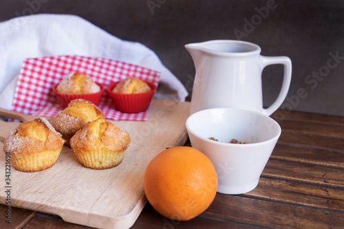 homemade muffins with orange juice for breakfast with gray background and on wooden board