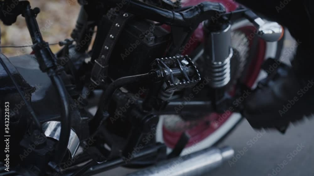 Close view of biker sitting on motorbike and rides Close view of biker sitting on motorbike and rides