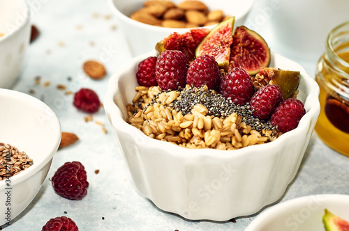 Oatmeal porridge with raspberry and figs in a bowl