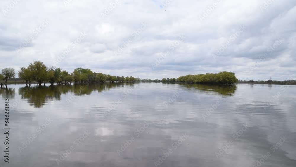 A river that overflowed its banks.Spring flood.Spring landscape.The river overflowed its banks,trees stand in water. A river that overflowed its banks.Spring flood.Spring landscape.The river overflowed its banks,trees stand in water.