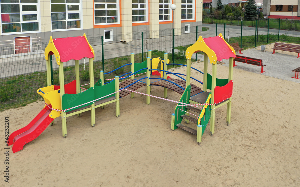 A closed playground for children with tape during the COVID-19 pandemic, Coronavirus. Aerial view A closed playground for children with tape during the COVID-19 pandemic, Coronavirus. Aerial view