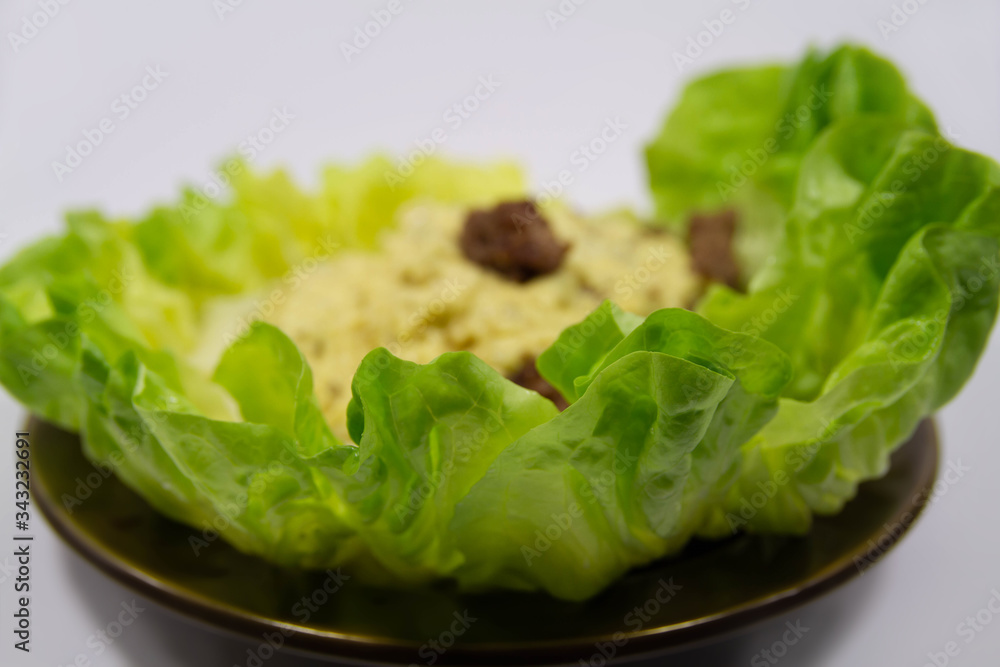 Lettuce arranged around a meal on a dark plate Lettuce arranged around a meal on a dark plate